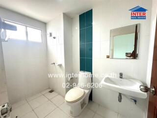 Spacious modern bathroom with white and aquamarine tiles