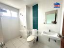 Spacious modern bathroom with white and aquamarine tiles