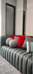 Elegant living room with grey sofa and vibrant red cushions