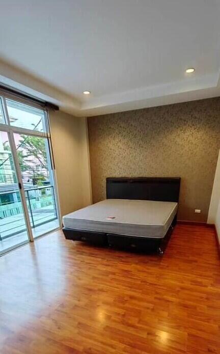 Spacious bedroom with hardwood floors and large window