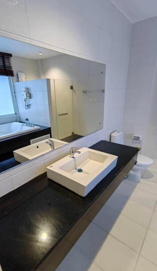 Modern bathroom interior with glass shower and wide mirror