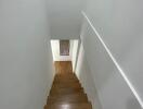 Wooden staircase with white walls in modern home