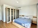 Spacious and bright bedroom with large bed and built-in wardrobes