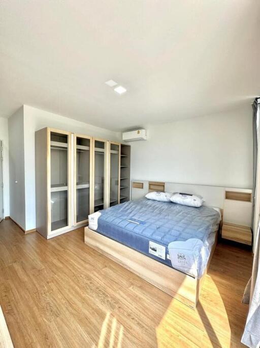 Spacious and bright bedroom with large bed and built-in wardrobes