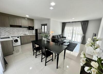 Modern open plan living space with integrated kitchen, dining area, and living room