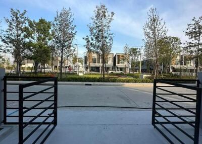 Outdoor view of modern residential complex with open gate and landscaped gardens