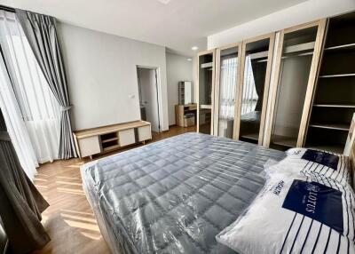 Spacious bedroom with large wardrobe and natural lighting