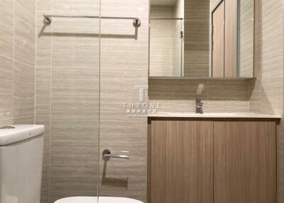 Modern bathroom with wooden cabinet and beige tiles
