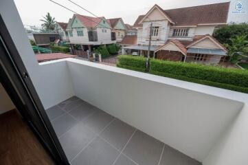 View from the balcony showcasing neighboring houses and safety barrier