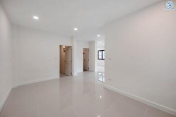 Spacious and bright empty living room with white walls and tiled floor
