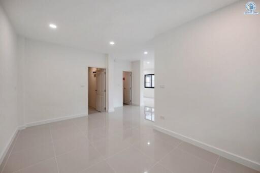 Spacious and bright empty living room with white walls and tiled floor