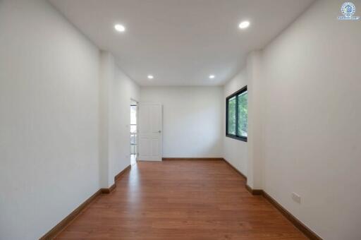 Spacious empty bedroom with hardwood flooring and white walls