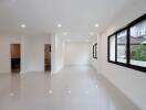 Spacious and bright living room with glossy white floor tiles