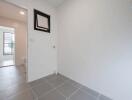 Bright and modern entryway with gray tiled flooring and white walls