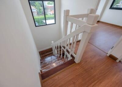Bright and modern staircase with wooden floors and railing