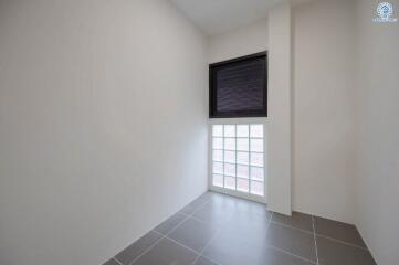 Bright empty room with large window and gray tiles