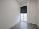 Bright empty room with large window and gray tiles