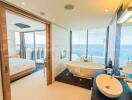 Luxurious bathroom with freestanding tub and view into bedroom with ocean view