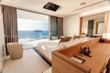 Spacious bedroom with ocean view through large glass window