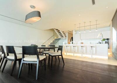 Modern kitchen and dining area with white theme and stylish staircase