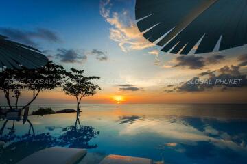 Luxurious infinity pool overlooking sunset with ocean view