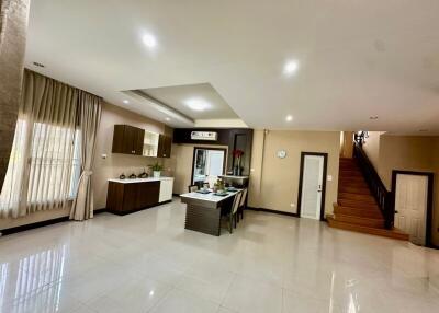 Spacious open plan living area with integrated kitchen, staircase and modern lighting
