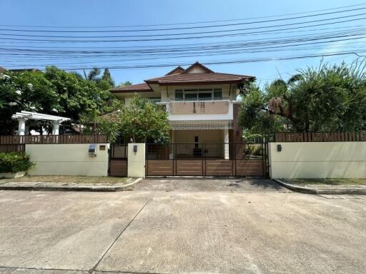 Front view of a spacious two-story house with a gated entrance