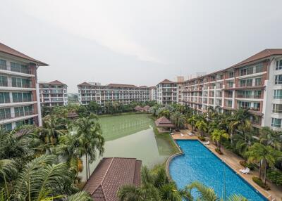 Aerial view of a residential building complex with swimming pool and lush landscaping