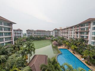 Aerial view of a residential building complex with swimming pool and lush landscaping