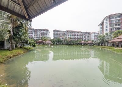 Spacious apartment complex with a central pond and lush greenery