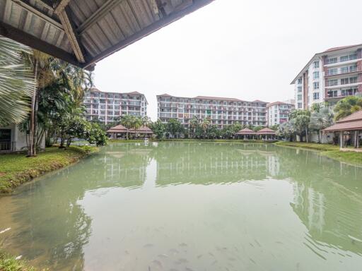 Spacious apartment complex with a central pond and lush greenery