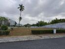 Wide angle view of a residential neighborhood with palm trees and modern buildings under a cloudy sky