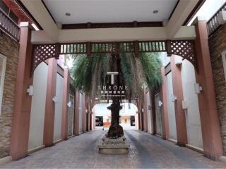 Elegant entrance to the Throne residential complex with decorative archways and lush palm tree