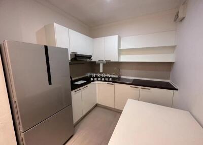 Modern compact kitchen with white cabinetry and stainless steel appliances