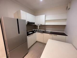 Modern compact kitchen with white cabinetry and stainless steel appliances