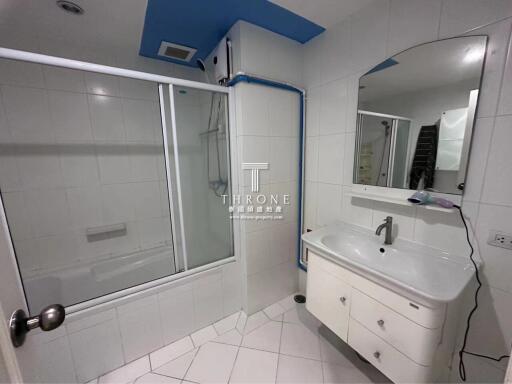 Spacious modern bathroom with glass shower and white vanity