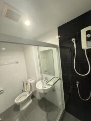 Modern bathroom with black and white tiles, shower, and essential fixtures