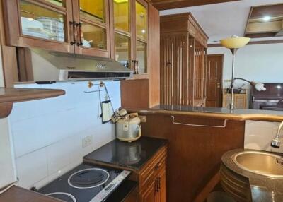 Compact and efficient kitchen space with wooden cabinets and modern appliances