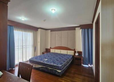 Spacious bedroom with elegant wood furnishing and ample natural light
