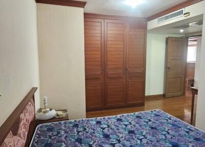 Spacious bedroom with large bed and elegant wooden wardrobe