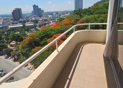 Spacious balcony with city view and flowering trees