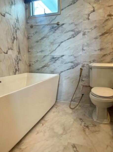 Modern bathroom with marble tiles and white fixtures