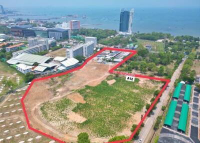 Aerial view of large coastal land property outlined in red