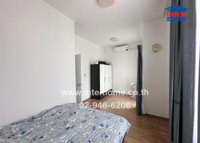 Compact bedroom with modern design, featuring a large bed and air conditioning