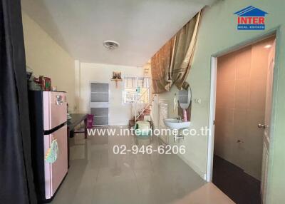 Compact kitchen area with fridge and access to bathroom