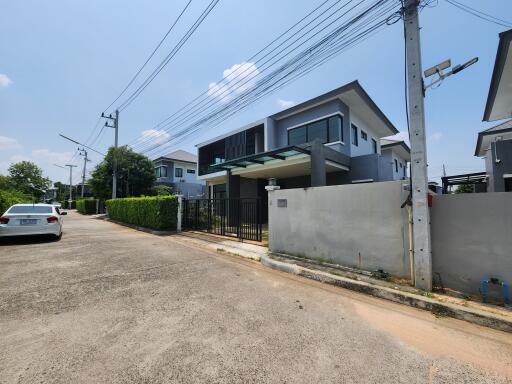 Modern two-story house with balcony and driveway in a residential area