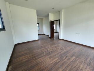 Spacious unfurnished living room with hardwood flooring and natural light