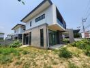 Modern two-story house with large windows and a well-maintained lawn