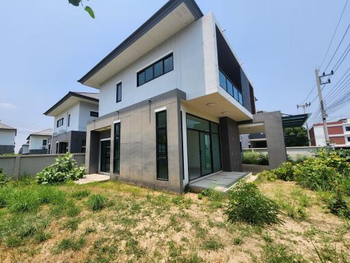 Modern two-story house with large windows and a well-maintained lawn