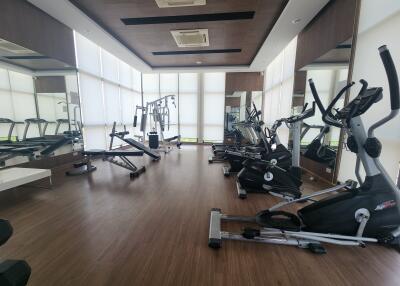 Well-equipped gym with various exercise machines and large windows